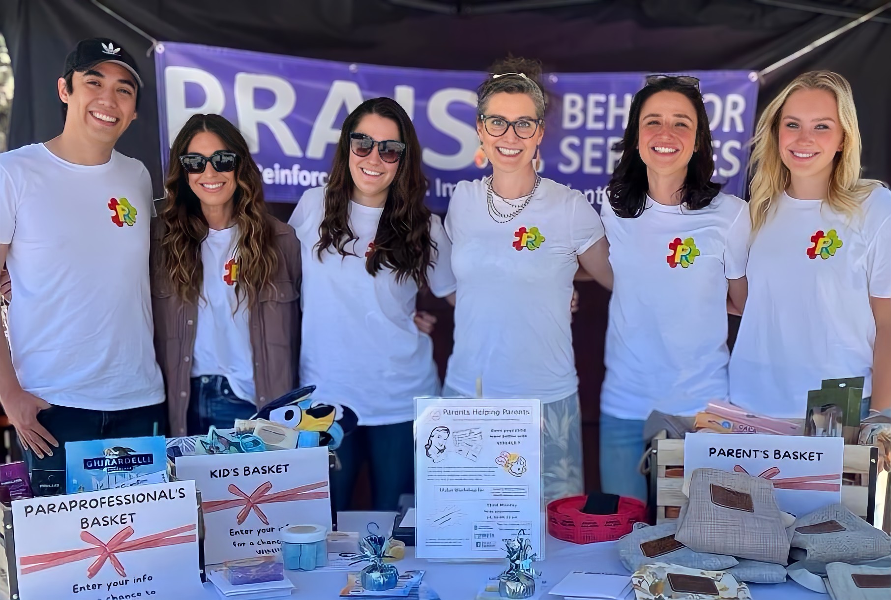 group of people at a Praise Behavior table at a community event